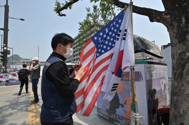 Un militant sud-coréen et pro-américain installe les deux drapeaux côte-à-côte près de l’ambassade américaine à Séoul, le 20 mai 2022, pour célébrer la visite de Joe Biden en Corée du Sud.