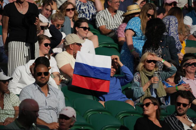 Un espectador sostiene una bandera rusa durante un partido entre el ruso Daniil Medvedev y el croata Marin Cilic en el campeonato anterior de Wimbledon el 3 de julio de 2021. 