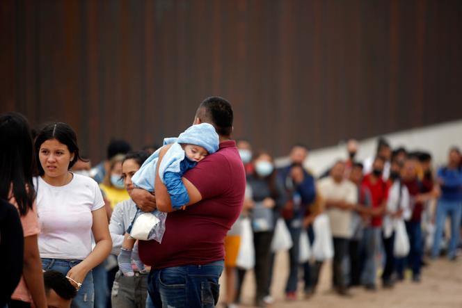 Migrantes que cruzaron el Río Grande para ingresar a territorio estadounidense esperan ser recogidos por la policía fronteriza el 20 de mayo de 2022 en Eagle Pass, Texas.