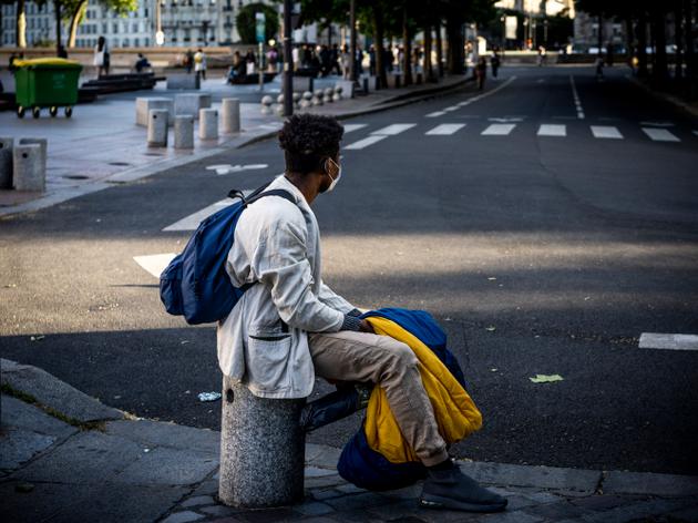 Un mineur isolé attend avec le sac de couchage qui vient de lui être distribué, à Paris, le 20 mai 2022.