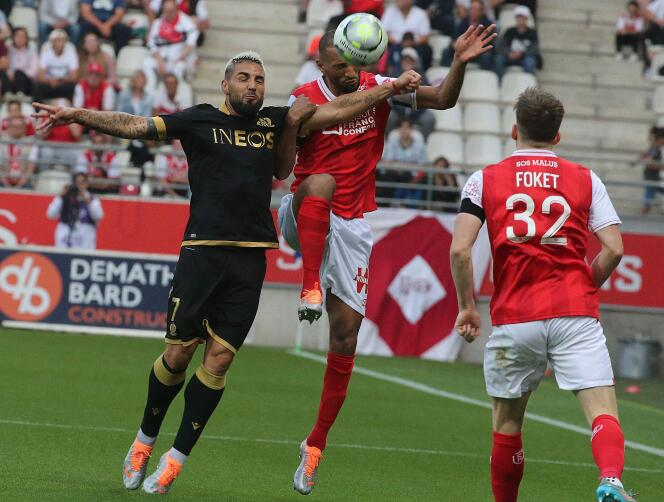 Reims defender Yunis Abdelhamid (center) in contact with Nice striker Andy Delort (left) during the match at the Auguste-Delaune stadium in Reims, May 21, 2022.