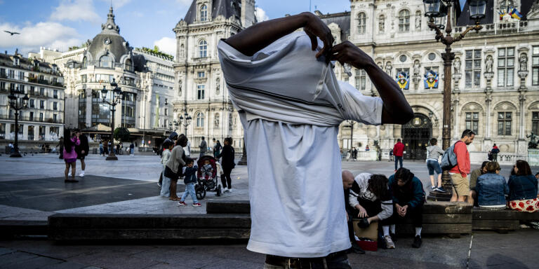 Un mineur isolé, qui n’a pas été reconnu mineur par l’administration française, essaye le tee-shirt qui lui a été distribué par l'association Utopia 56 lors d'un rassemblement sur le parvis de l’hôtel de ville de Paris.