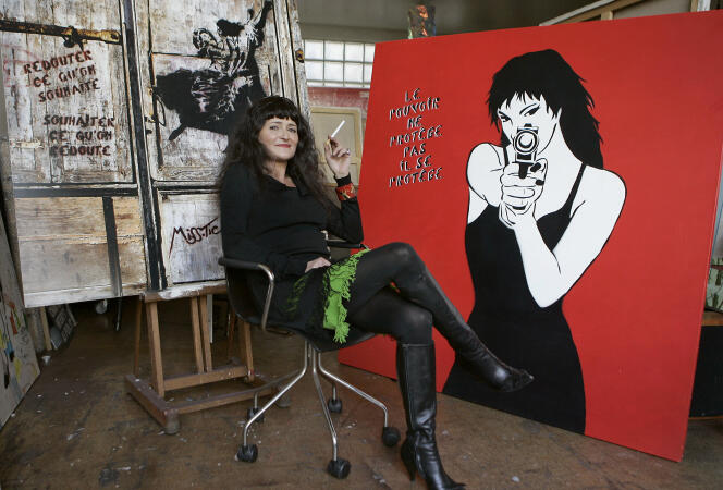 L'artiste Miss Tic pose à côté de l'une de ses œuvres dans son atelier, le 31 janvier 2006 à Paris.  Cette figure de l'art de la rue, dont les pochoirs habillent les murs de la capitale depuis vingt ans, a publié un livre, « Miss Tic à Paris », en novembre dernier.  PHOTO BERTRAND GUAY (Photo par BERTRAND GUAY / AFP)