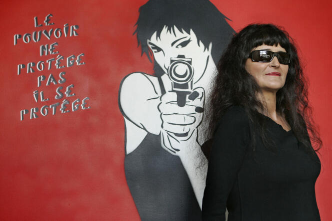 La artista Miss.Tic posa junto a una de sus obras en su estudio, el 31 de enero de 2006 en París.  Esta figura del street art, cuyas plantillas adornan las paredes de la capital desde hace veinte años, publicó el pasado mes de noviembre un libro, “Miss.Tic in Paris”.  AFP FOTO BERTRAND GUAY (Foto por BERTRAND GUAY / AFP)