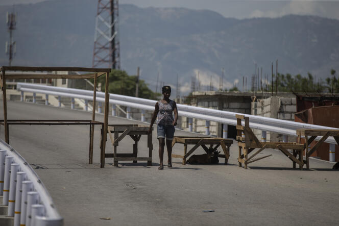 Una mujer pasa frente a una barricada erigida por pandilleros en Croix-des-Missions, al norte de Port-au-Prince, Haití, el 28 de abril de 2022. Las pandillas están tomando el control de las principales carreteras que conectan la capital con el resto del país y secuestran víctimas a diario.