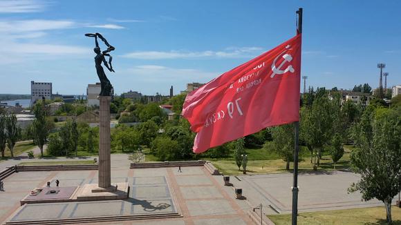 Une réplique de la bannière de la victoire soviétique flotte près d’un mémorial de la seconde guerre mondiale, dans la ville de Kherson en Ukraine, le 20 mai 2022.