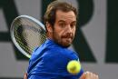 France's Richard Gasquet returns the ball to South Africa's Lloyd Harris during their men's singles match at the Court Suzanne-Lenglen on day two of the Roland-Garros Open tennis tournament in Paris on May 23, 2022. (Photo by Christophe ARCHAMBAULT / AFP)