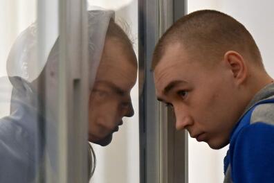 Russian sergeant Vadim Shishimarin listens court sentence in the defendant's box on the last day of his trial on charges of war crimes for having killed a civilian, at a courthouse in Kyiv on May 23, 2022. A Kyiv court ruled on May 23, 2023 that a 21-year-old Russian soldier who killed a civilian was guilty of war crimes and handed him a life sentence, in the first verdict against Moscow's forces since their invasion. Shishimarin, a Russian sergeant, admitted early in court to killing 62-year-old Oleksandr Shelipov in the first days of the Kremlin's offensive in north-east Ukraine. (Photo by Sergei SUPINSKY / AFP)