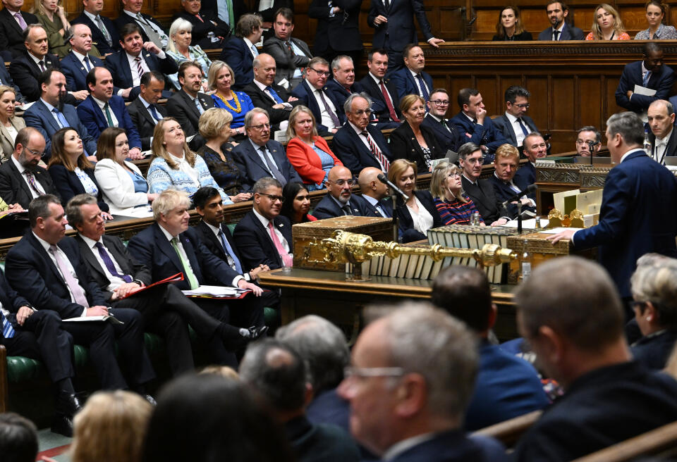 A handout photograph released by the UK Parliament shows the Conservative benches listening as Britain's main opposition Labour Party leader Keir Starmer (R) speaks during prime minister's questions in the House of Commons in London on May 18, 2022. (Photo by JESSICA TAYLOR / UK PARLIAMENT / AFP) / RESTRICTED TO EDITORIAL USE - NO USE FOR ENTERTAINMENT, SATIRICAL, ADVERTISING PURPOSES - MANDATORY CREDIT " AFP PHOTO / Jessica Taylor /UK Parliament"