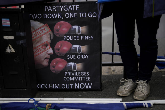 Un manifestant anti-Johnson et anti-Brexit exhibe une pancarte devant le palais de Westminster, le Parlement, à Londres ce mercredi 25 mai 2022.