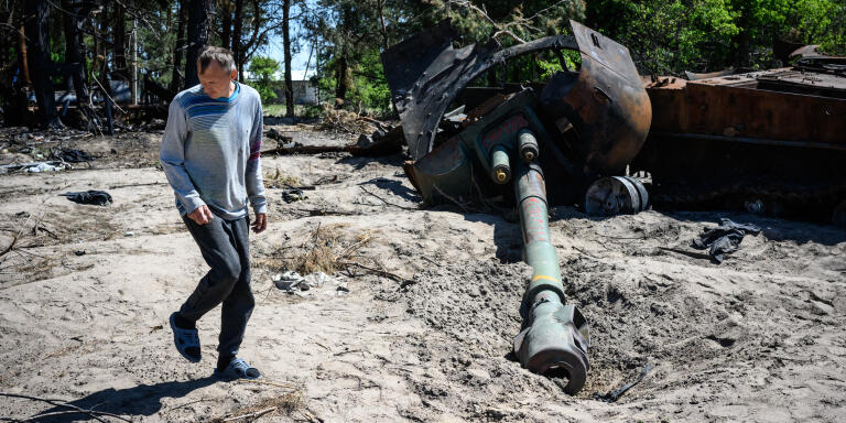 Berestyanka- Kyiv Oblast- May 19, 2022-Ukraine. At the exit of the town of Nove Zalissya, along the road T1019 leading to Berestyanka, a man looks at the remains of a Russian tank. The army had established a military position at the intersection of roads T1019 and T1011. The town of Nove Zalissya was built after the Chernobyl disaster to relocate the inhabitants of Zalissya located next to the town of Chernobyl. The inhabitants were evacuated on May 4, 1986. And the city was built 6 months after the disaster by workers coming from Crimea. During the Russian attack in 2022, it was occupied by the Russian army.