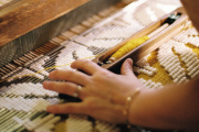 A weaver makes the Verne model on a creel loom, recognizable by its bobbin placed at the beginning of the loom.