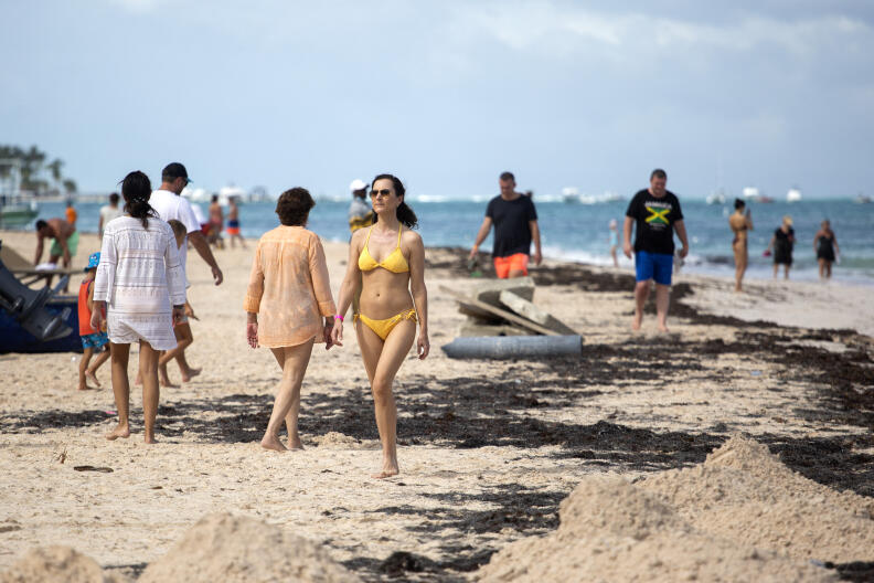 Tourists enjoy a beach in Punta Cana in the Dominican Republic, on January 7, 2022. - Almost 5 million tourists visited Dominican Republic in 2021, compared to the 6.4 million reported in 2019 before the pandemic started. With a significant growth in tourism and at the same time of infections by Covid-19, hotels in the Dominican Republic allocate areas to isolate tourists sick with the virus. (Photo by Erika SANTELICES / AFP)