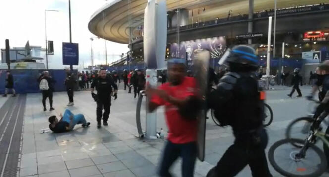 Capture d’une vidéo de l’AFP montrant la police maîtrisant des personnes qui tentaient d’escalader les grilles du Stade de France, le 28 mai 2022.
