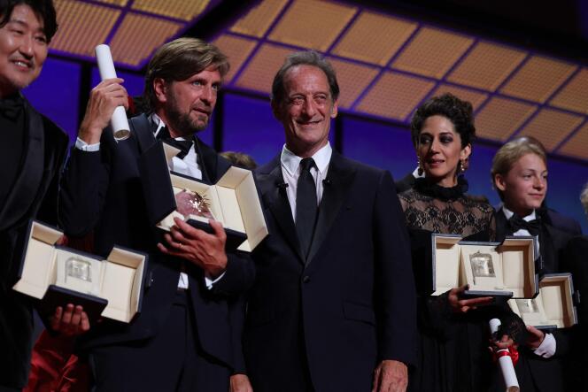 Swedish film director Ruben Ostlund, President of the Jury of the 75th Cannes Film Festival Vincent Lindon and Iranian actress Zahra Amir Ebrahimi and Belgian actor Eden Dambrine pose at the end of the closing ceremony, on May 28, 2022. 