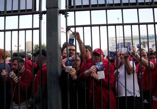 Los seguidores del Liverpool muestran sus boletos para ingresar al Stade de France el 28 de mayo de 2022.