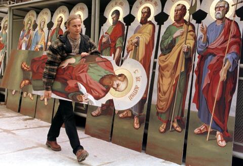 A restoration worker carries an icon of St. Matthew next to other apostles' images being made ready for mounting at the renovated Uspensky Cathedral at Pechersk Lavra monastery in Kiev October 14. The Ukrainian Orthodox church celebrates the festival of Protection of The Virgin today. YK/CVI