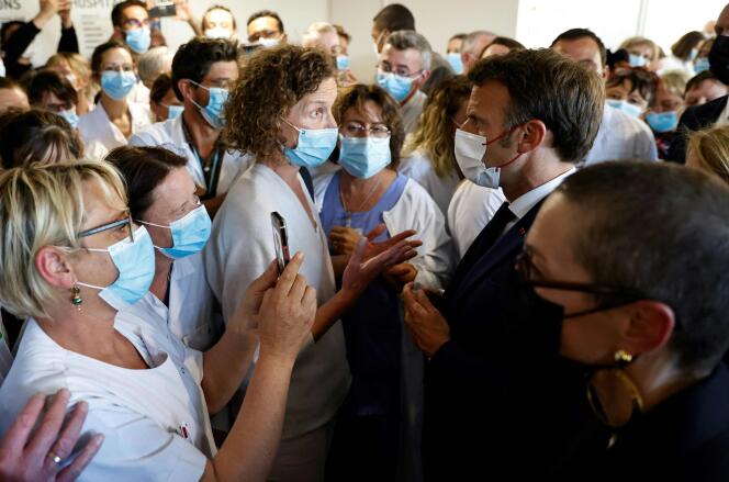 French President Emmanuel Macron talks with a health worker at the public hospital in Cherbourg, Normandy, France, on May 31 2022. 