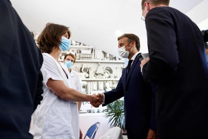 French President Emmanuel Macron greets a health worker at the public hospital in Cherbourg, on May 31 2022.