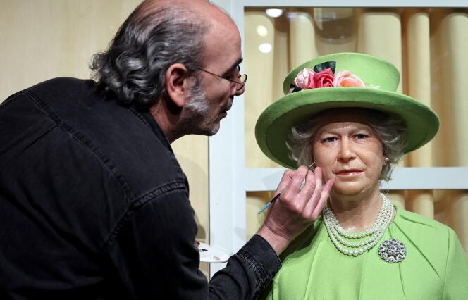 An artist renovates the wax statue of British Queen Elisabeth II at the Musee Grevin in Paris on June 2, 2022.