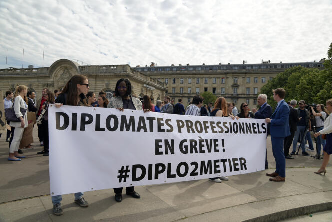 Diplomats hold a banner reading 