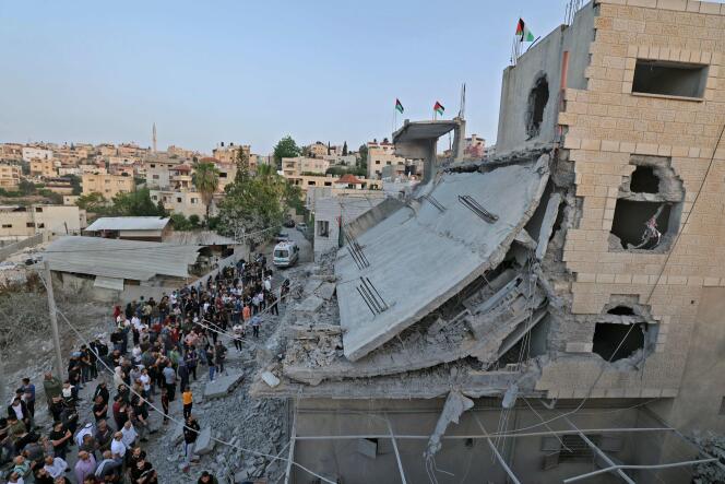 People gather outside the destroyed family home of the perpetrator of an attack that left five people dead in Bnei Brak, Israel, on June 2, 2022, in Yabad.