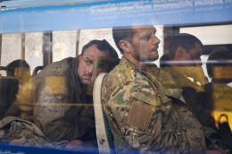 FILE - Ukrainian servicemen sit in a bus after they were evacuated from the besieged Mariupol's Azovstal steel plant, near a remand prison in Olyonivka, in territory under the government of the Donetsk People's Republic, eastern Ukraine, May 17, 2022. Three months after it invaded Ukraine hoping to overtake the country in a blitz, Russia has bogged down in what increasingly looks like a war of attrition with no end in sight. (AP Photo/Alexei Alexandrov, File)