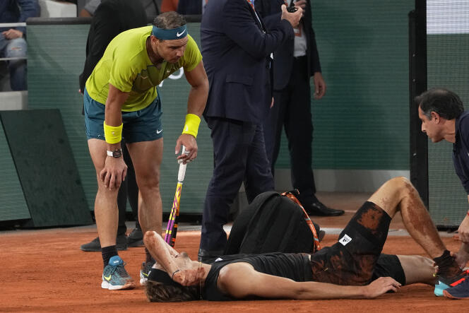 Spain's Rafael Nadal watches Germany's Alexander Zverev laying on the clay after falling during their semifinal match of the French Open tennis tournament at the Roland Garros stadium Friday, June 3, 2022 in Paris. Alexander Zverev stopped playing because of an injury. (AP Photo/Michel Euler)