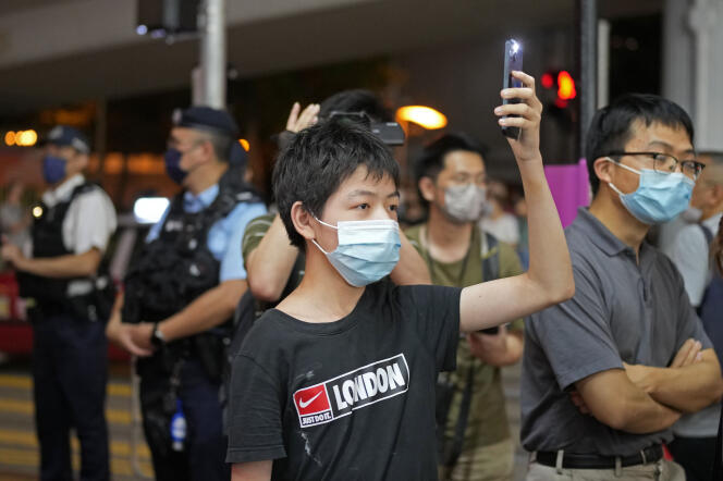 Un manifestant pro-démocratie hongkongais lève son téléphone portable, lampe allumée, en souvenir de l’écrasement de la manifestation de 1989, à Hongkong, le 4 juin 2022.