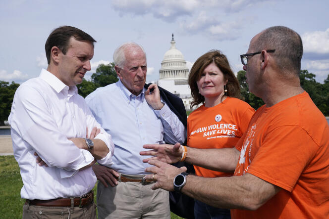 Le sénateur démocrate Chris Murphy (à gauche), et le représentant républicain Mike Thompson (2e à gauche) discutent avec des militants d’un plus grand contrôle des armes, lors d’un rassemblement à Washington, le 10 juin 2022. 