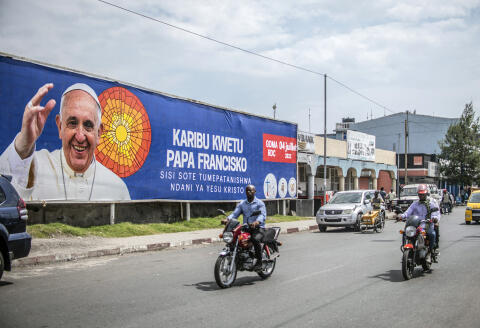People drive past a banner welcoming Pope Francis to Goma, Democratic Republic of Congo, Friday June 10, 2022. Pope Francis canceled a planned July trip to Africa on doctors' orders because of ongoing knee problems, the Vatican said, raising further questions about the health and mobility problems of the 85-year-old pontiff. (AP Photo/Moses Sawasawa)