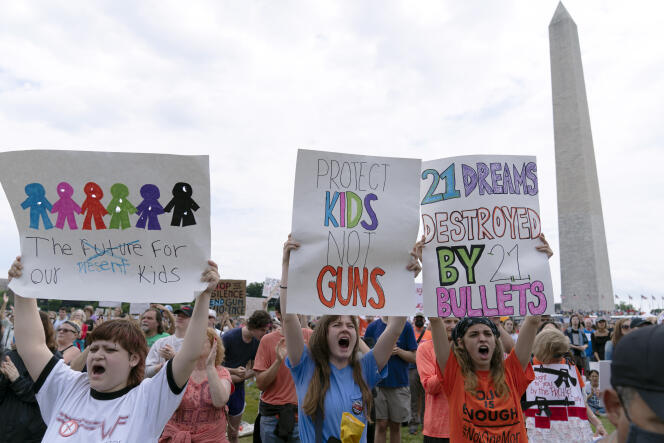 People hold signs during the March for Our Lives rally in support of gun control in front of the Washington Monument on June 11, 2022, in Washington.