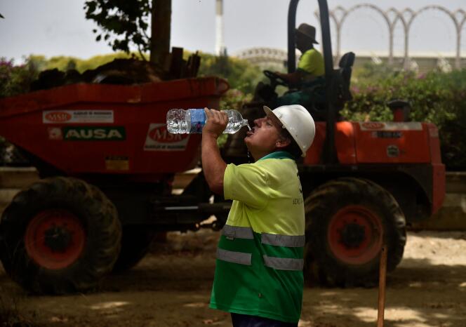 A construction worker drinks water to beat the heat in Seville, June 13, 2022. Spain is already in a heat wave that is expected to reach 