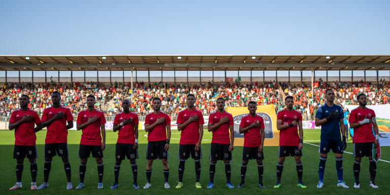 Les 11 joueurs titulaires de l'équipe nationale de football de Libye lors du jeu de l'hymne national. Avant le match qui l'opposera à l'équipe du Bostwana. Le 1er juin 2022 à Benghazi.