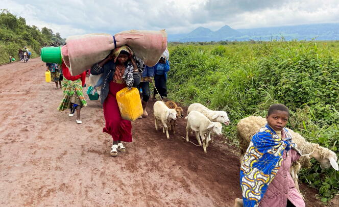 Congolese families flee between army and M23 rebels on May 24, 2022, near the Rwandan border in North Kivu.