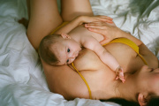 Viola breastfeeding her 5-month-old daughter, Lyra, in her bed.