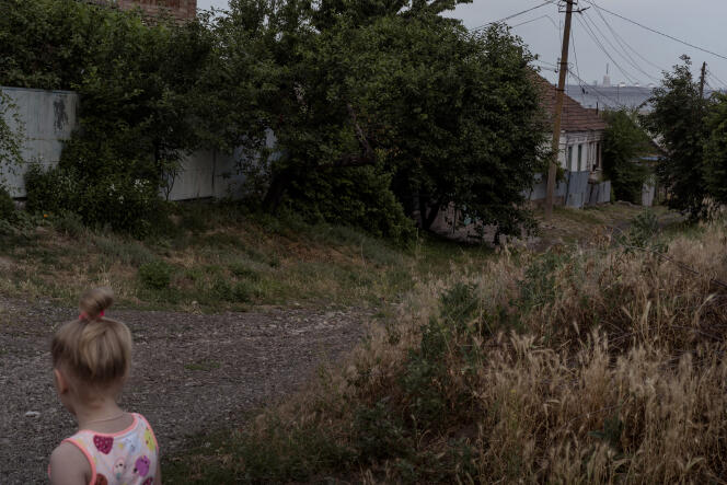 Une jeune fille marche dans les rues de Nikopol, d'où l'on aperçoit la centrale nucléaire de Zaporijia, en Ukraine, le 15 juin 2022.