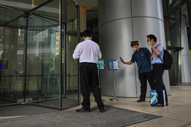 Une personne doit scanner son code santé pour entrer dans un bâtiment officiel, à Shanghaï, en Chine, le 1er juin 2022. 