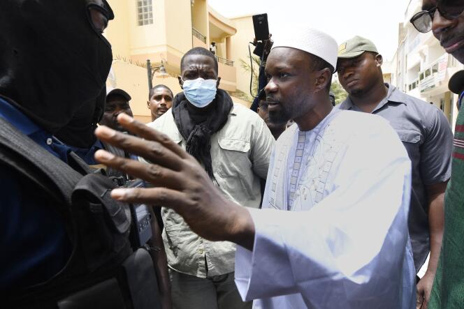 La figure de l’opposition sénégalaise Ousmane Sonko discute avec des membres de la police devant sa résidence, à Dakar le 17 juin 2022. 