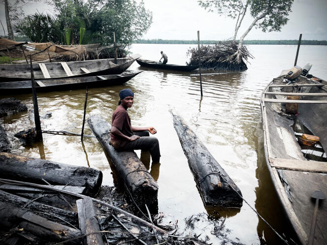 Onitsha Joseph, les pieds dans l’eau souillée par le pétrole, devant le camp de pêcheur de la communauté de Benikrukru, dans le delta du Niger, au Nigeria, le 23 avril 2022.