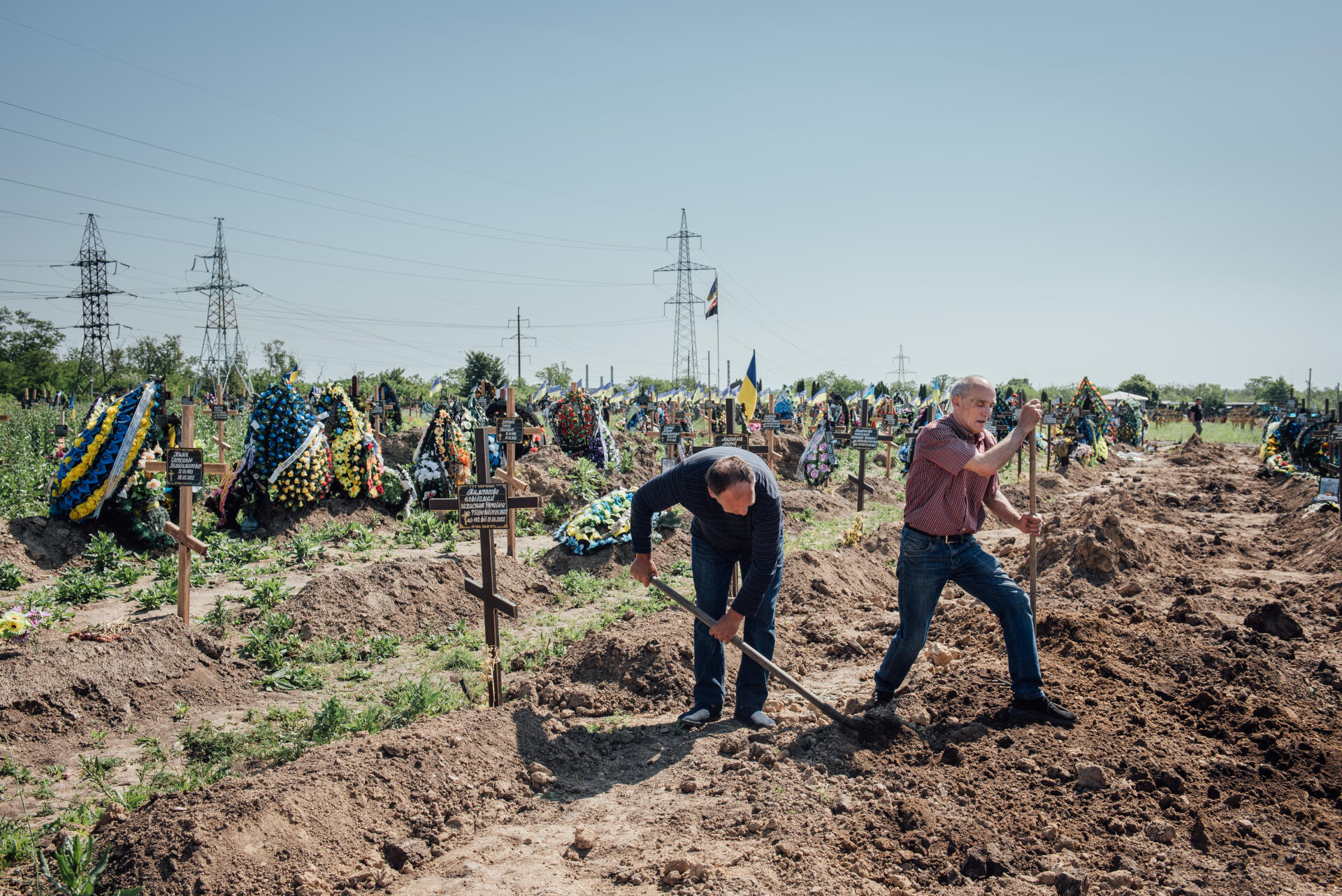 Deux hommes entretiennent le cimétière de Krasnopilske. Dnipro le 11 juin 2022.