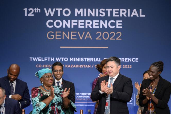 La directrice générale de l’Organisation mondiale du commerce, Ngozi Okonjo-Iweala (à gauche), applaudit à côté du président de la conférence, Timur Suleimenov, après une séance de clôture d’une conférence ministérielle de l’OMC à Genève, le 17 juin 2022.
