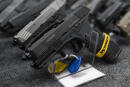 FILE - Pistols sit on display during the first day of the Silver Spur Gun and Blade Show Saturday, Jan. 22, 2022 in Odessa, Texas. On Friday, June 17, 2022, The Associated Press reported on stories circulating online incorrectly claiming a bill passed by the Democrat-led U.S. House of Representatives would criminalize disassembling, cleaning and re-assembling your gun without a firearm manufacturer’s license. (Eli Hartman/Odessa American via AP)