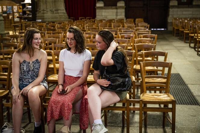 Florianne, Angéline, and Elisa Martinez enjoy the coolness of the Saint-Germain church, in Rennes, on June 17, 2022.
