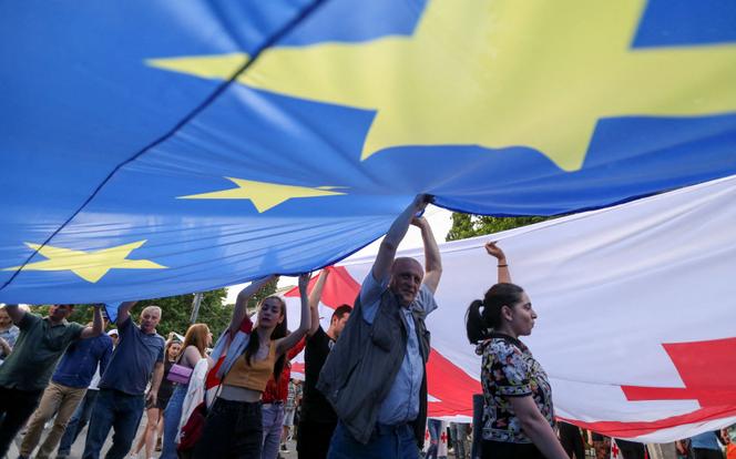 Los manifestantes despliegan enormes banderas europeas y georgianas durante el desfile en Tbilisi el 20 de junio de 2022.