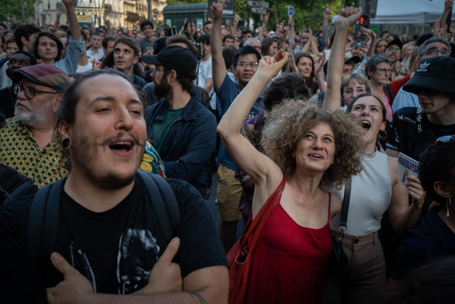 Des sympathisants de la Nupes fêtent les bons résultats de leur coalition, le 19 juin 2022, devant la salle de spectacle de l'Elysée-Montmartre à Paris, au soir du second tour des élections législatives.