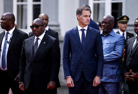 Belgium’s Prime Minister Alexander De Croo (R) and Democratic Republic of Congo's Prime Minister Jean-Michel Sama Lukonde pay their respects during a ceremony to hand over a tooth of Democratic Republic of Congo's first prime minister and independence hero Patrice Lumumba at the Egmont Palace in Brussels, on June 20, 2022. - Former colonial master Belgium hosted an official ceremony to return the slain Congolese leader's tooth -- all that is left of the anti-colonialist icon who was murdered by Congolese separatists and Belgian mercenaries in 1961. (Photo by Kenzo TRIBOUILLARD / AFP)