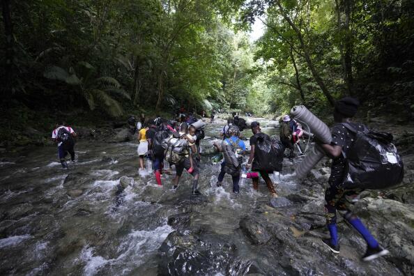 Migrants cross the Acandi River on their journey north, near Acandi, Colombia, on Sept. 15, 2021. The migrants, mostly Haitians, are on their way to crossing the Darien Gap from Colombia into Panama dreaming of reaching the U.S. (AP Photo/Fernando Vergara)