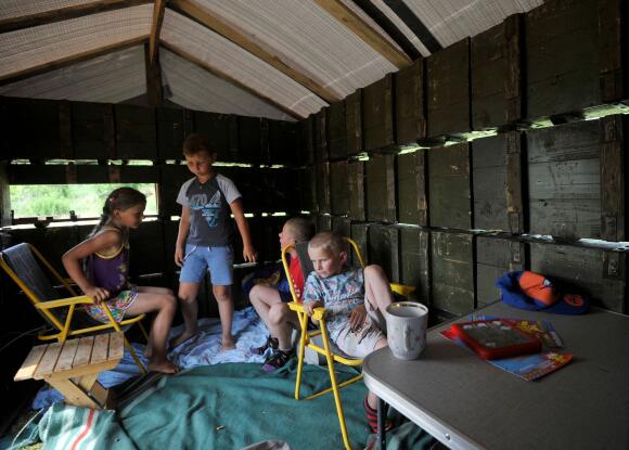 Des enfants jouent dans une cabane construite en caisses de munitions, dans le village de Novoselivka, près de Tchernihiv, le 21 juin 2022.