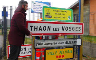 Remplacement du panneau « Thaon les Vosges, Commune de Capavenir Vosges » en « Thaon-les-Vosges » (on voit à l’arrière un bout du panneau où l’on distingue « Capavenir Vosges ».